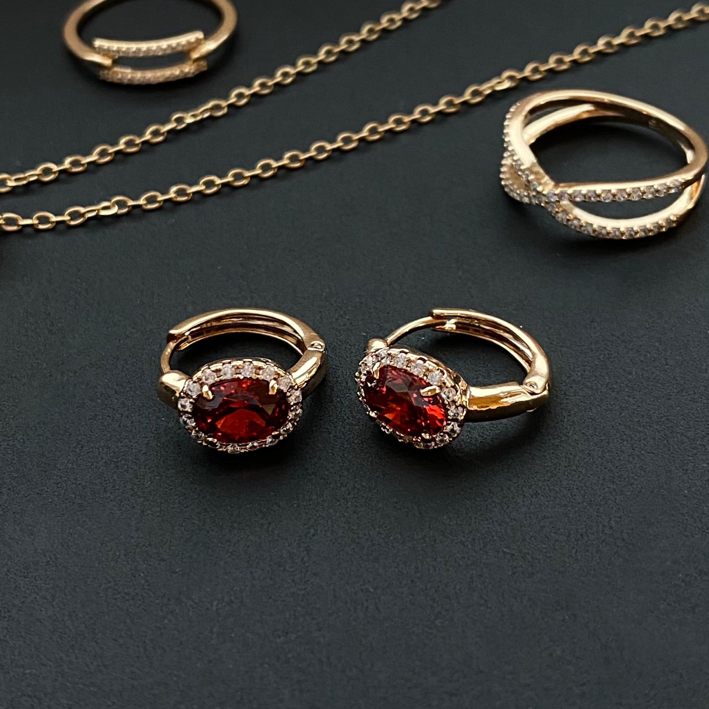 Apzeltīti riņķīšu auskari ar sarkanu cirkoniju